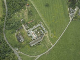 Oblique aerial view centred on the farmsteading and gate-lodge, taken from the NW.