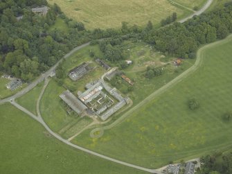 Oblique aerial view centred on the farmsteading and gate-lodge, taken from the SW.