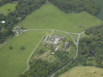Oblique aerial view centred on the farmsteading, stallion house and gate-lodge, taken from the E.