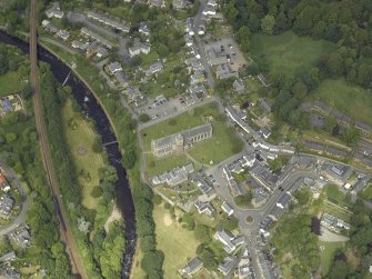 Oblique aerial view of the town centred on the cathedral, chapel, burial-ground and hall with the railway viaduct adjacent, taken from the S.