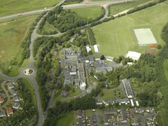 Oblique aerial view centred on the school, church, hospital and house, taken from the SSE.