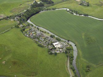Oblique aerial view of the village centred on the woollen mill, taken from the N.