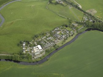 Oblique aerial view of the village centred on the woollen mill, taken from the W.