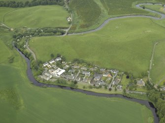 Oblique aerial view of the village centred on the woollen mill, taken from the SSW.