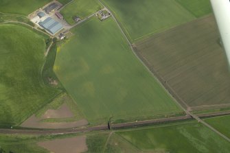 Oblique aerial view centred on the cropmarks of the unenclosed settlement, rig and pits, taken from the WNW.