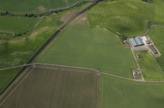 Oblique aerial view centred on the cropmarks of the unenclosed settlement, rig and pits, taken from the SE.