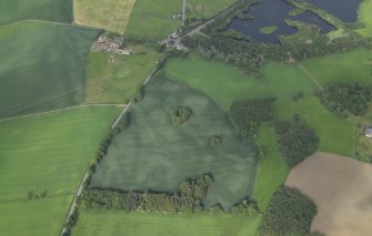 Oblique aerial view centred on the cropmarks of the pits and rig with the farmhouse and farmsteading adjacent, taken from the SW.