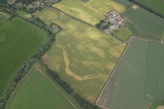 Oblique aerial view centred on the cropmarks of the cursus with the cropmarks of the possible settlement and the farmhouse, farm buildings and dovecot adjacent, taken from the SE.