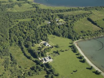 Oblique aerial view centred on the country house and farmsteading with the country house and the remains of the fish trap adjacent, taken from the NNW.