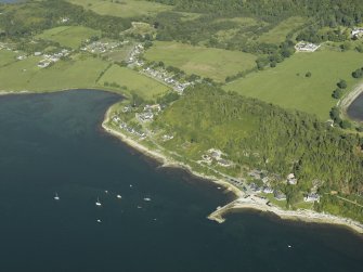 General oblique aerial view of the village centred on the jetty and ferry house with the country house and farmsteading adjacent, taken from the W.