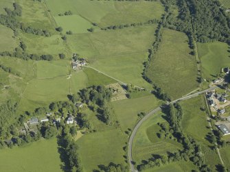 Oblique aerial view centred on the church and burial-ground with the country house adjacent, taken from the NW.