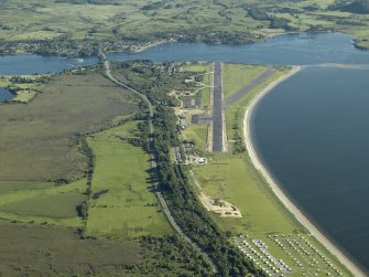 General oblique aerial view centred on the airfield during resurfacing of the runway with the village, road bridge and railway bridge adjacent, taken from the NNE.