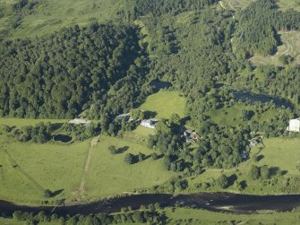 General oblique aerial view centred on the country house and the suspension bridge, taken from the SW.