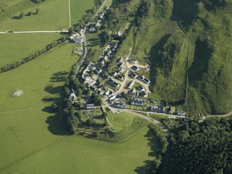 General oblique aerial view of the village, centred on the church, churchyard, burial ground, museum and the remains of the cairn with the tower-house adjacent, taken from the SSW.