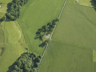 Oblique aerial view centred on the remains of the stone circles with the remains of the standing stone adjacent, taken from the SSW.
