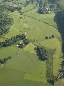 General oblique aerial view of the Kilmartin valley centred on the remains of the chambered cairn, standing stones, stone setting and cairns and the farmstead and school, taken from the S.