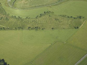 Oblique aerial view centred on the remains of the standing stones, henge and barrow, taken from the ESE.