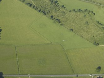 Oblique aerial view centred on the remains of the standing stones, henge and barrow, taken from the ENE.