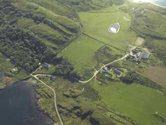 Oblique aerial view centred on the farmhouses, farmsteading and cottages, taken from the SW.