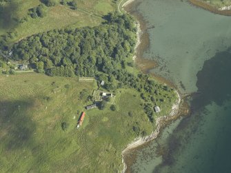 Oblique aerial view centred on the remains of the chapel and burial-ground and the cottages, taken from the SE.