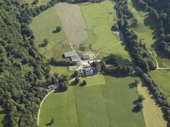 Oblique aerial view centred on the country house with the remains of the cairn adjacent, taken from the WSW.