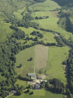General oblique aerial view with the country house in the foreground with the remains of the cairn adjacent, taken from the SW.