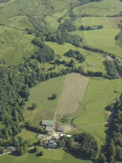 General oblique aerial view with the country house in the foreground with the remains of the cairn adjacent, taken from the SSW.