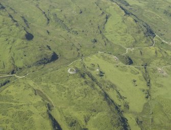 Oblique aerial view centred on the remains of the dun, taken from the NNE.