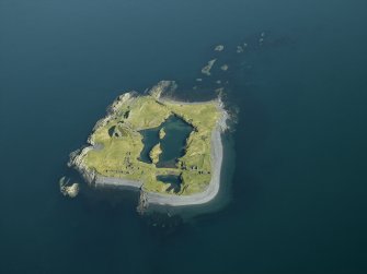 Oblique aerial view of the island, centred on the remains of the slate quarries, taken from the SSE.