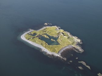 Oblique aerial view of the island, centred on the remains of the slate quarries, taken from the NE.