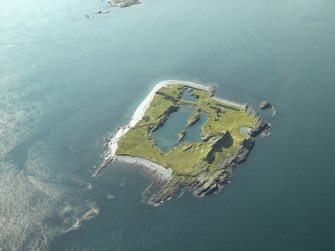 Oblique aerial view of the island, centred on the remains of the slate quarries, taken from the NW.