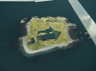 Oblique aerial view of the island, centred on the remains of the slate quarries, taken from the E.