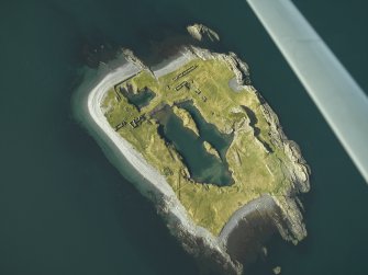 Oblique aerial view of the island, centred on the remains of the slate quarries, taken from the NE.