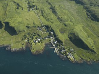 General oblique aerial view centred on the church, pier and cottages, taken from the SW.