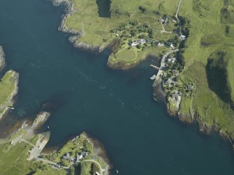 General oblique aerial view centred on the church, pier and cottages, taken from the S.