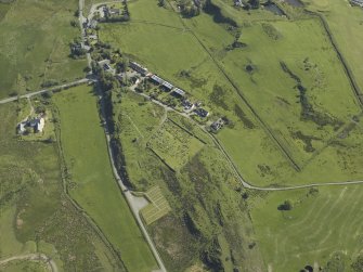 Oblique aerial view centred on the church and burial ground with the remains of the township adjacent, taken from the SW.