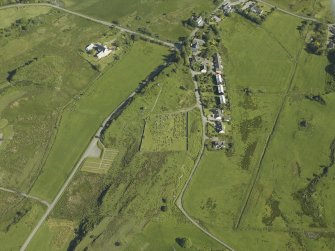 Oblique aerial view centred on the church and burial ground with the remains of the township adjacent, taken from the SSW.