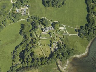 Oblique aerial view centred on the country house, terraced garden and dovecots with the farmsteading, farmhouse and stables adjacent, taken from the SE.