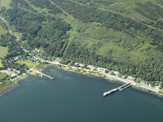 General oblique aerial view of the village centred on the pier and the jetty, taken from the NE.