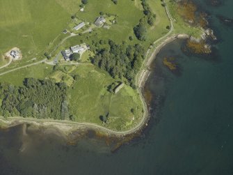 Oblique aerial view centred on the remains of the castle, hall-house and building with the farmhouse and farmsteading adjacent, taken from the S.
