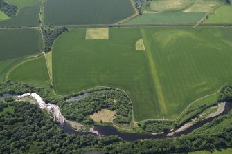 SOblique aerial view centred on the cropmarks of the rig with the cropmarks of the possible unenclosed settlement adjacent, taken from the NNW.