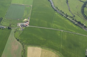 Oblique aerial view centred on the cropmarks of the rig with the farmhouse and farmsteading adjacent, taken from the NW.