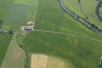 Oblique aerial view centred on the cropmarks of the rig with the farmhouse and farmsteading adjacent, taken from the NNW.