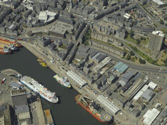 Oblique aerial view centred on the dock with the church, museum, cinema and high-rise flats adjacent, taken from the SE.