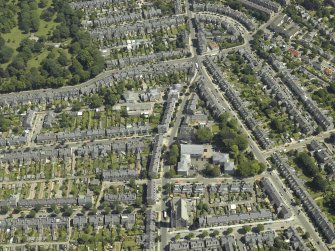 Oblique aerial view centred on the church, manse and the house, taken from the W.