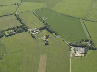 Oblique aerial view centred on the remains of the tower-house with the farmsteading adjacent, taken from the NNW.