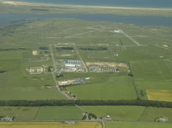 General oblique aerial view centred on the farmsteading and farmhouse with the remains of the airfield adjacent, taken from the SW.