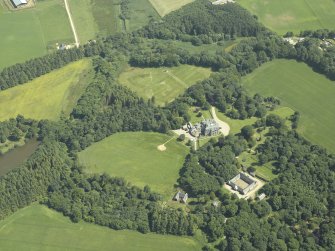 Oblique aerial view centred on the country house, stable block and walled garden, taken from the NW.