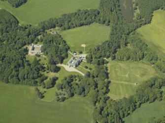 Oblique aerial view centred on the country house, stable block and walled garden, taken from the S.
