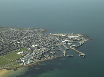 General oblique aerial view of the town centred on the harbour, taken from the SE.